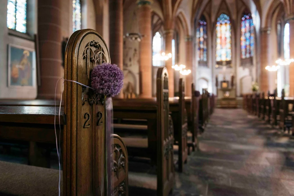 Kirchenschiff mit Blumenschmuck an den Bänken